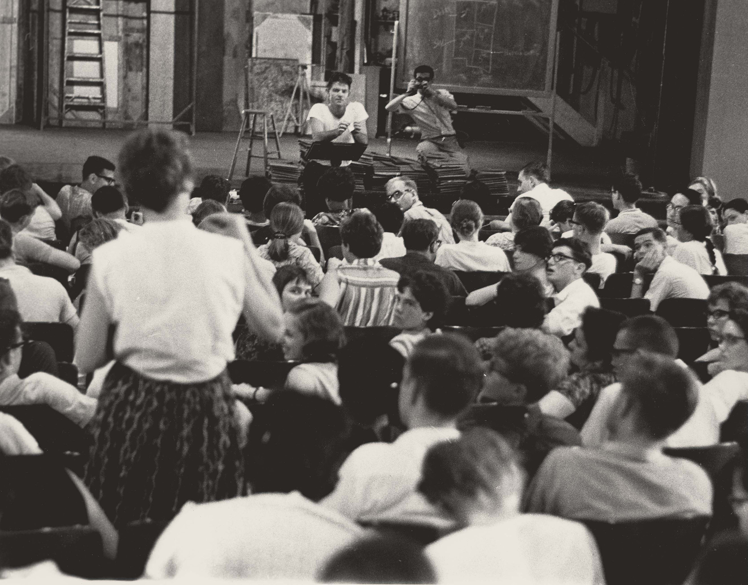Dr. Staughton Lynd Talks to Volunteers, June 1964. Photograph by Herbert Randall. Dr. Staughton Lynd, director of the Freedom Schools, talks to a large group of Freedom Summer volunteers in Peabody Hall on the Western College campus while SNCC staff photographer, Tamio 
