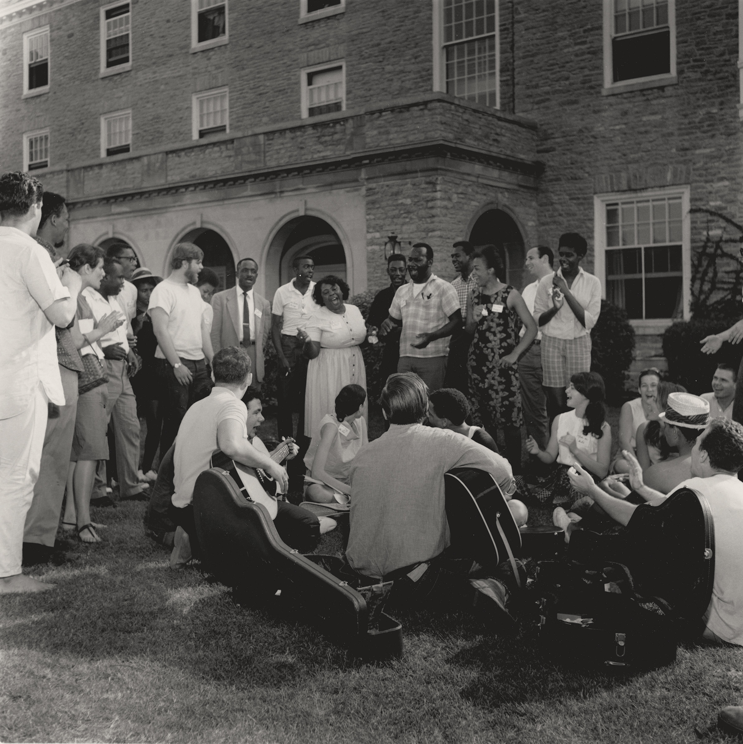 Student Volunteers Sing with Fannie Lou Hamer, June 1964. Photograph by George R. Hoxie. Fannie Lou Hamer sings with Freedom Summer volunteers outside of Western College's Clawson Hall. George R. Hoxie Photograph Collection at the Smith Library of Regional History. 